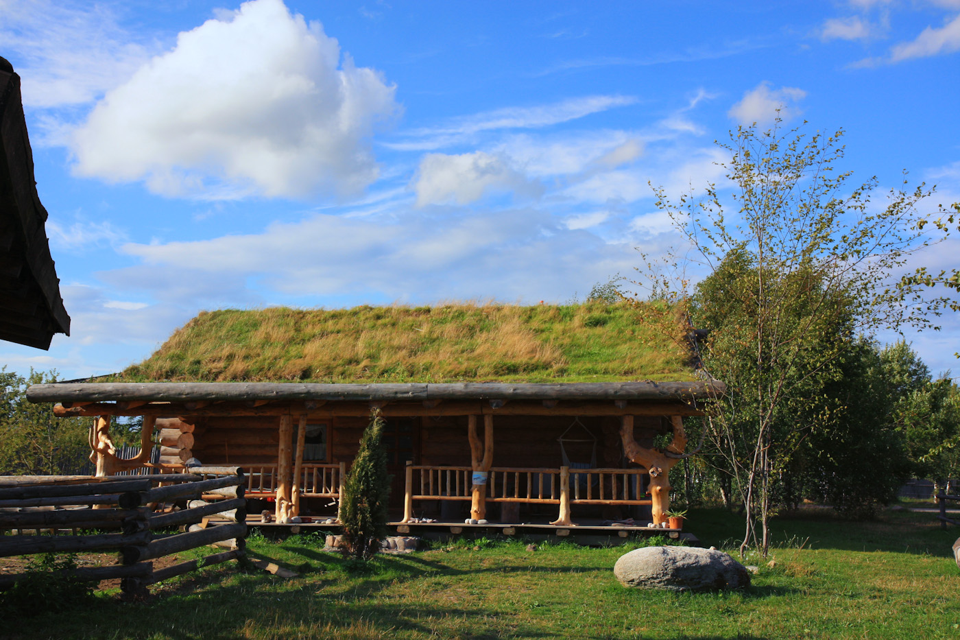 Baumstammhaus mit Grasdach